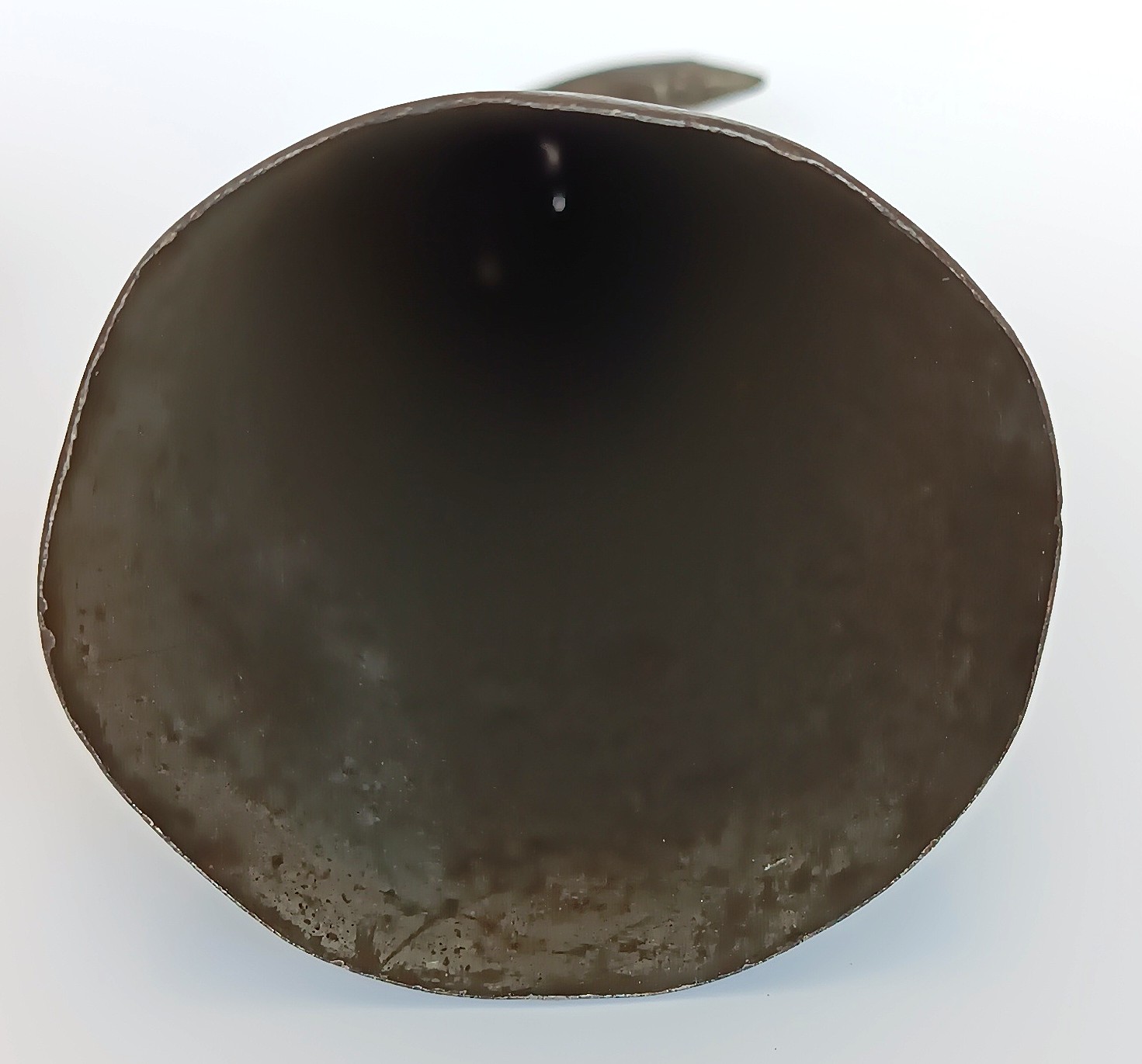 Interior of antique forged iron pig scraper bell showing open base and aged surface