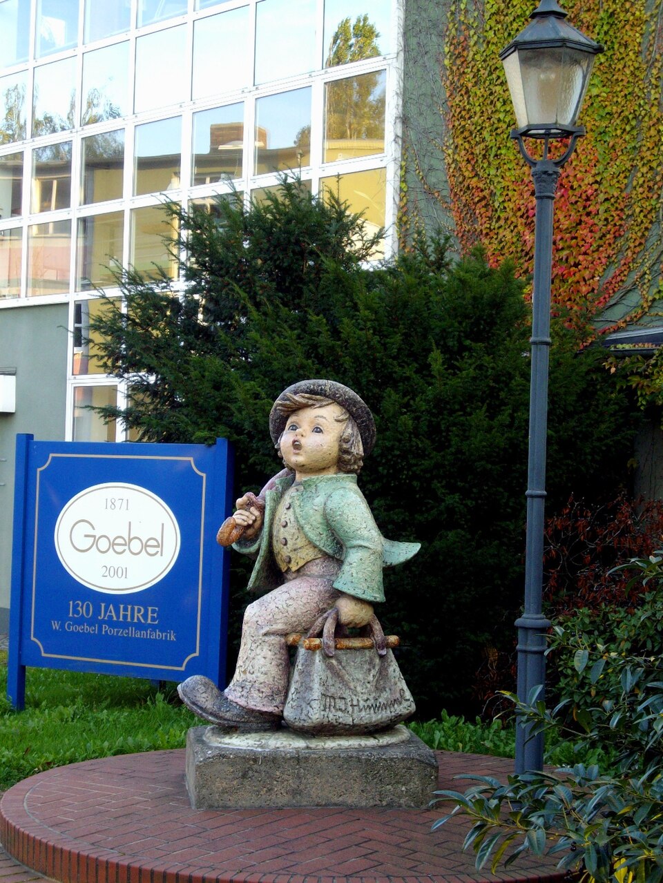 Hummel Figure at Goebel Factory – 130 Years of Goebel Monumental Hummel figure beside the Goebel 130th anniversary sign at the factory in Rodental Germany