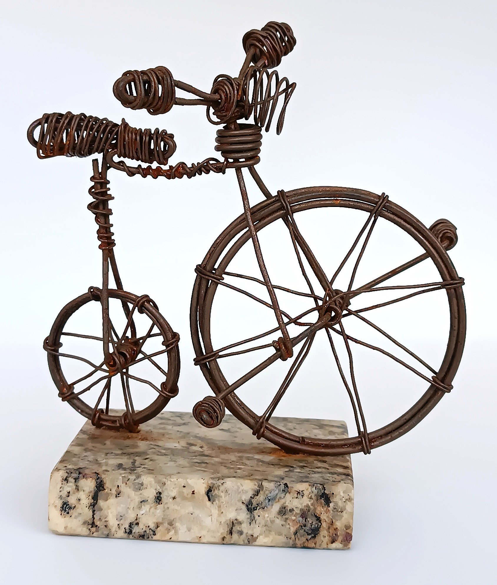 Handmade Penny-farthing wire bicycle sculpture on natural stone base