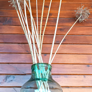 Vintage green glass 8-litre demijohn used as a decorative vase with dried flowers