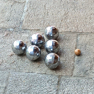 Vintage pétanque set with 6 solid metal boules and a wooden cochonnet arranged for play