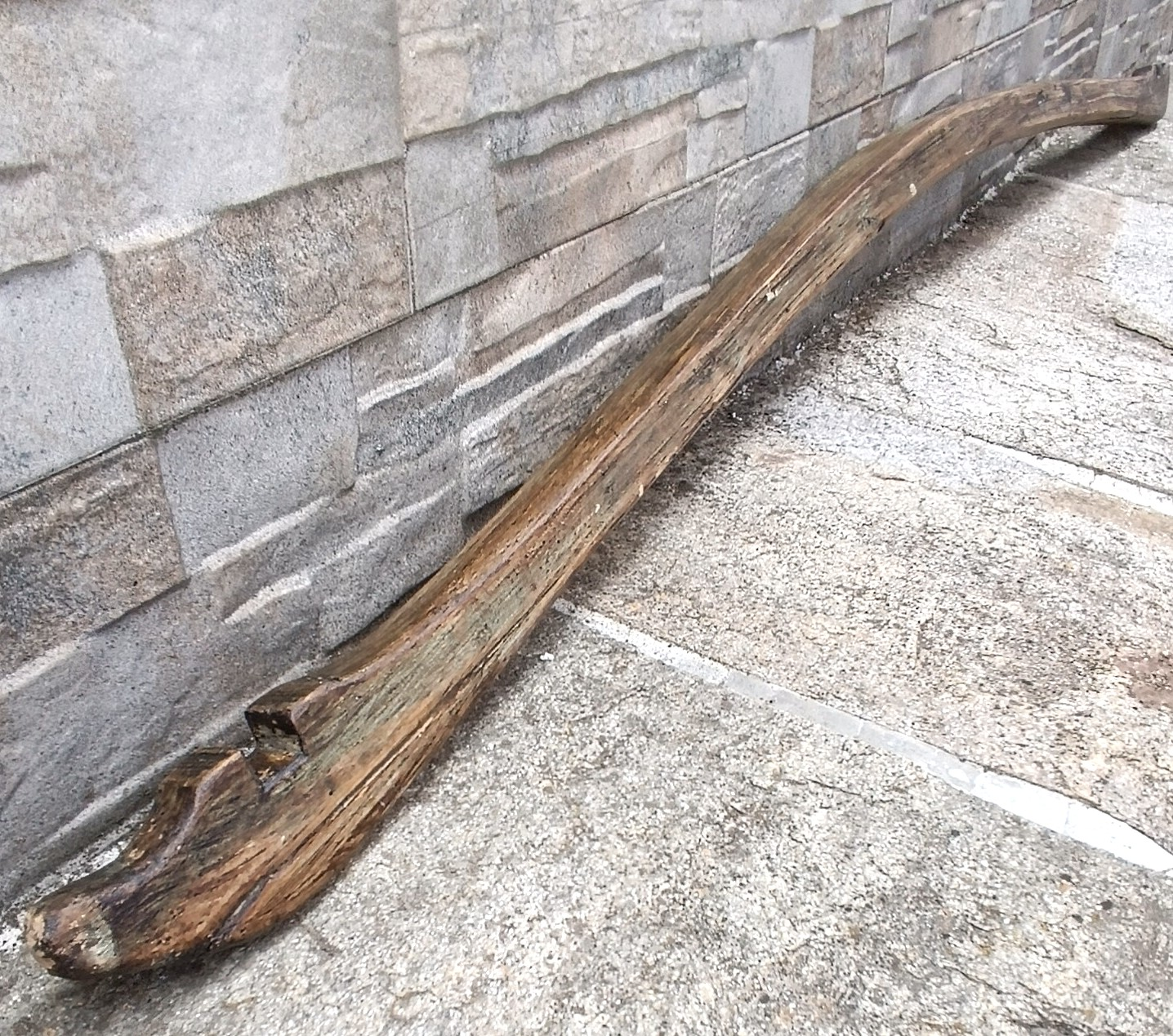 Detailed view of an antique Balkan wooden shoulder yoke from the Pavlikeni region, showing the curved body, aged patina and carved end slot