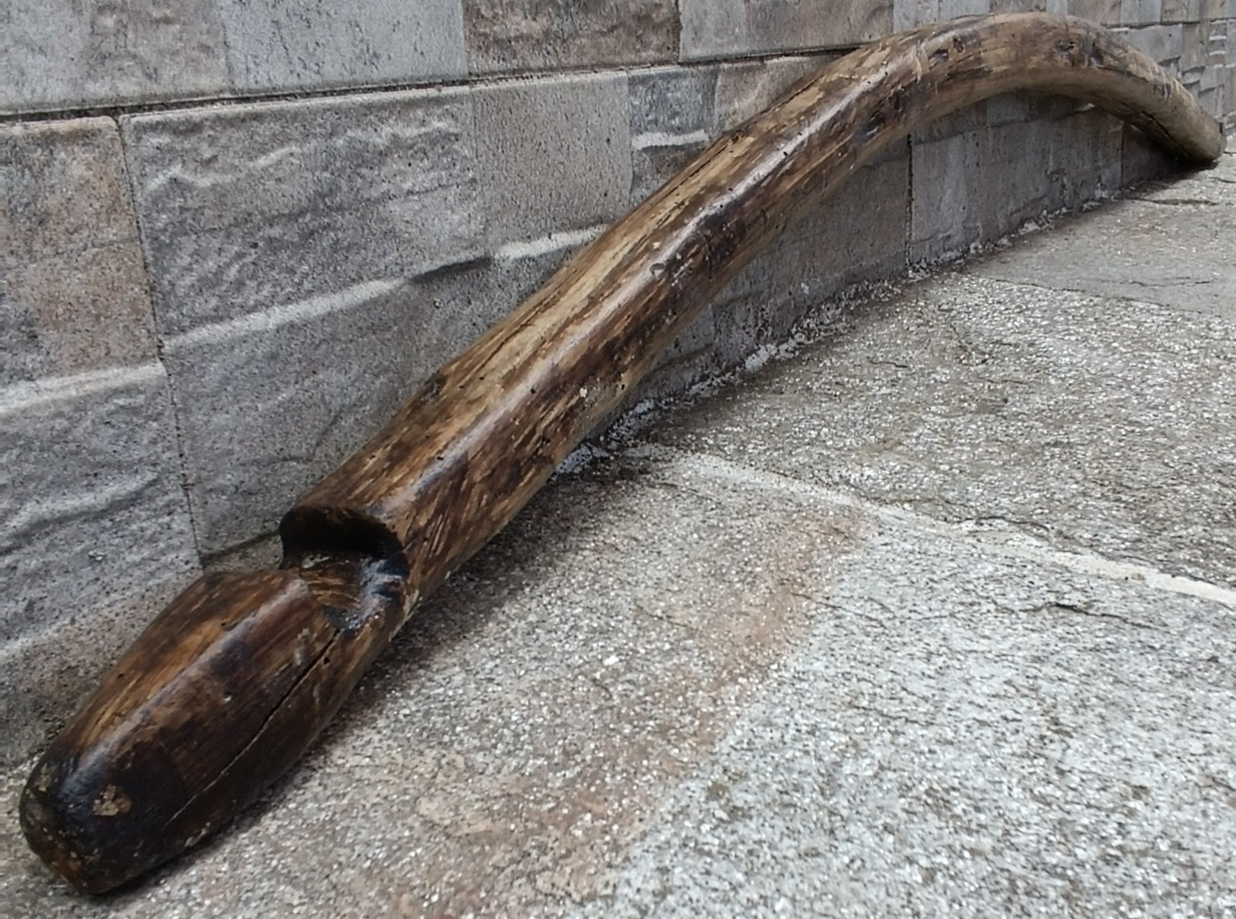 Antique Bulgarian wooden shoulder yoke from Central Bulgaria showing its pronounced curved form, carved end notch and naturally aged patina