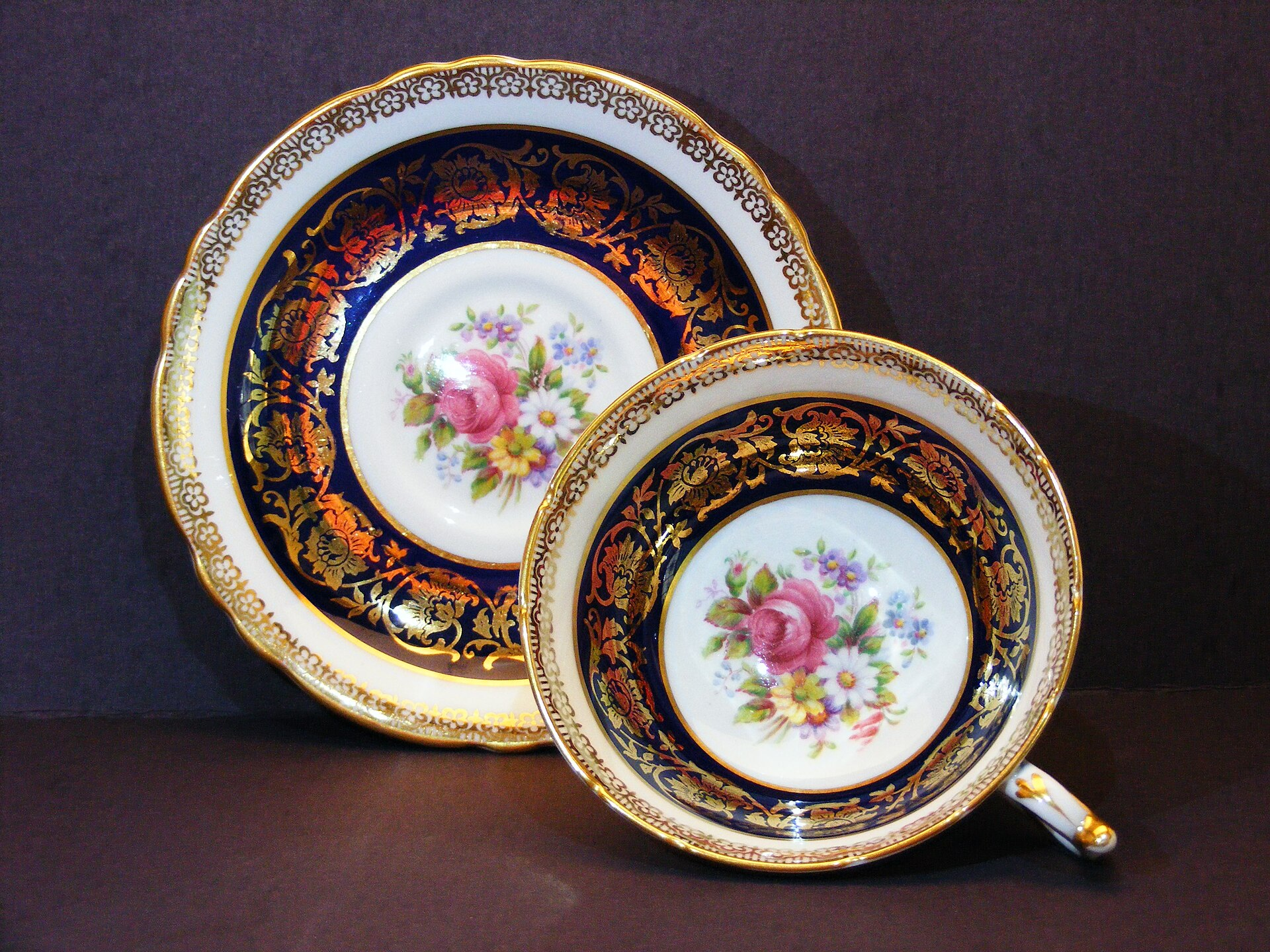 Paragon China teacup and saucer with cobalt blue bands, gold decoration and central floral bouquets