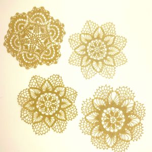 Set of four vintage handmade crochet doilies with different openwork floral patterns, each approximately 19 cm in diameter