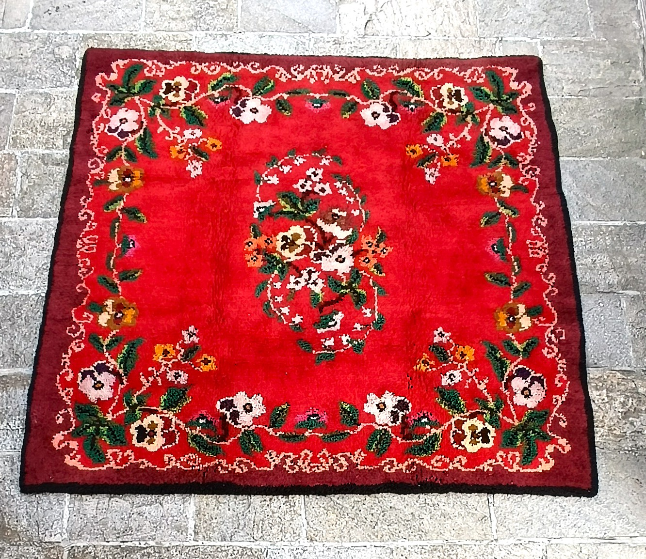 Vintage Bulgarian handwoven wool kitenik with a red field, central floral medallion and richly decorated botanical border, approx. 190 x 190 cm