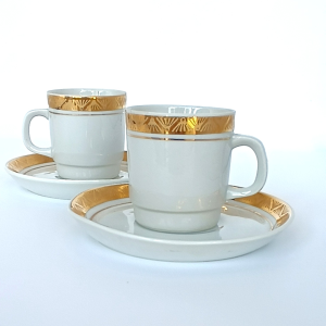 Two vintage Bulgarian porcelain coffee cups with matching saucers, decorated with wide gold bands and geometric fan motifs