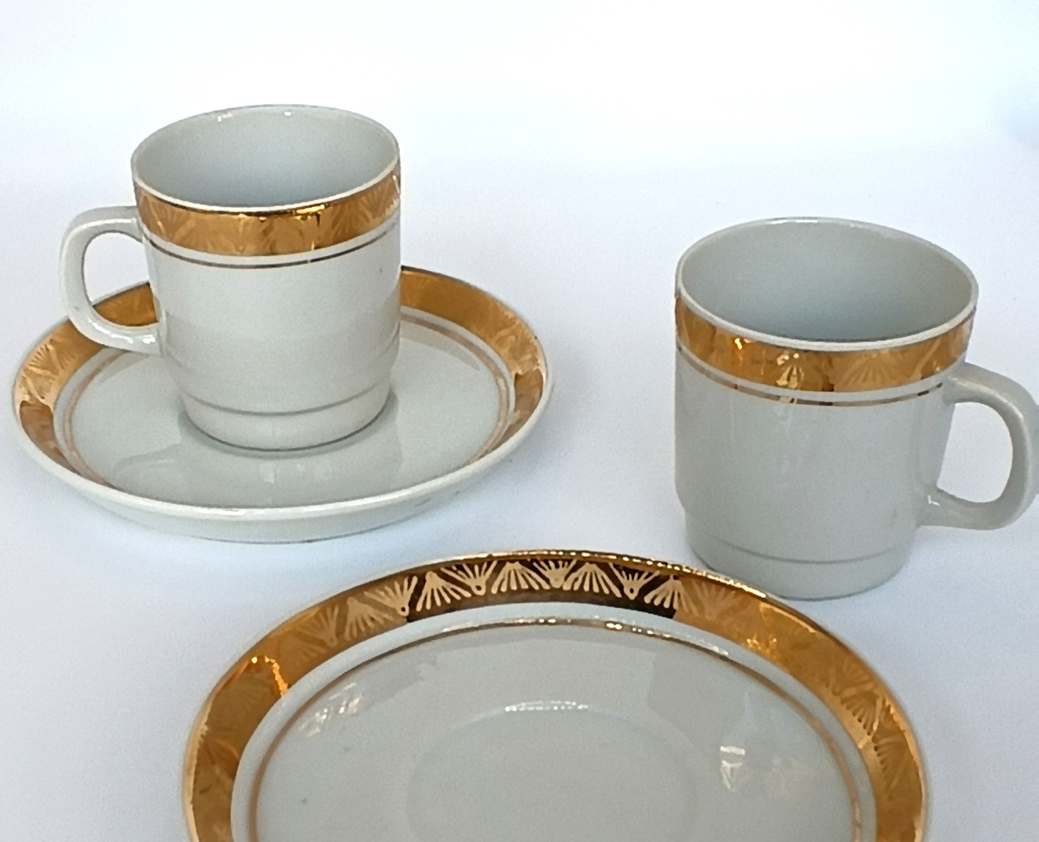 Vintage Bulgarian porcelain coffee set with two white cups and saucers decorated with wide gold geometric borders and fine gold lines