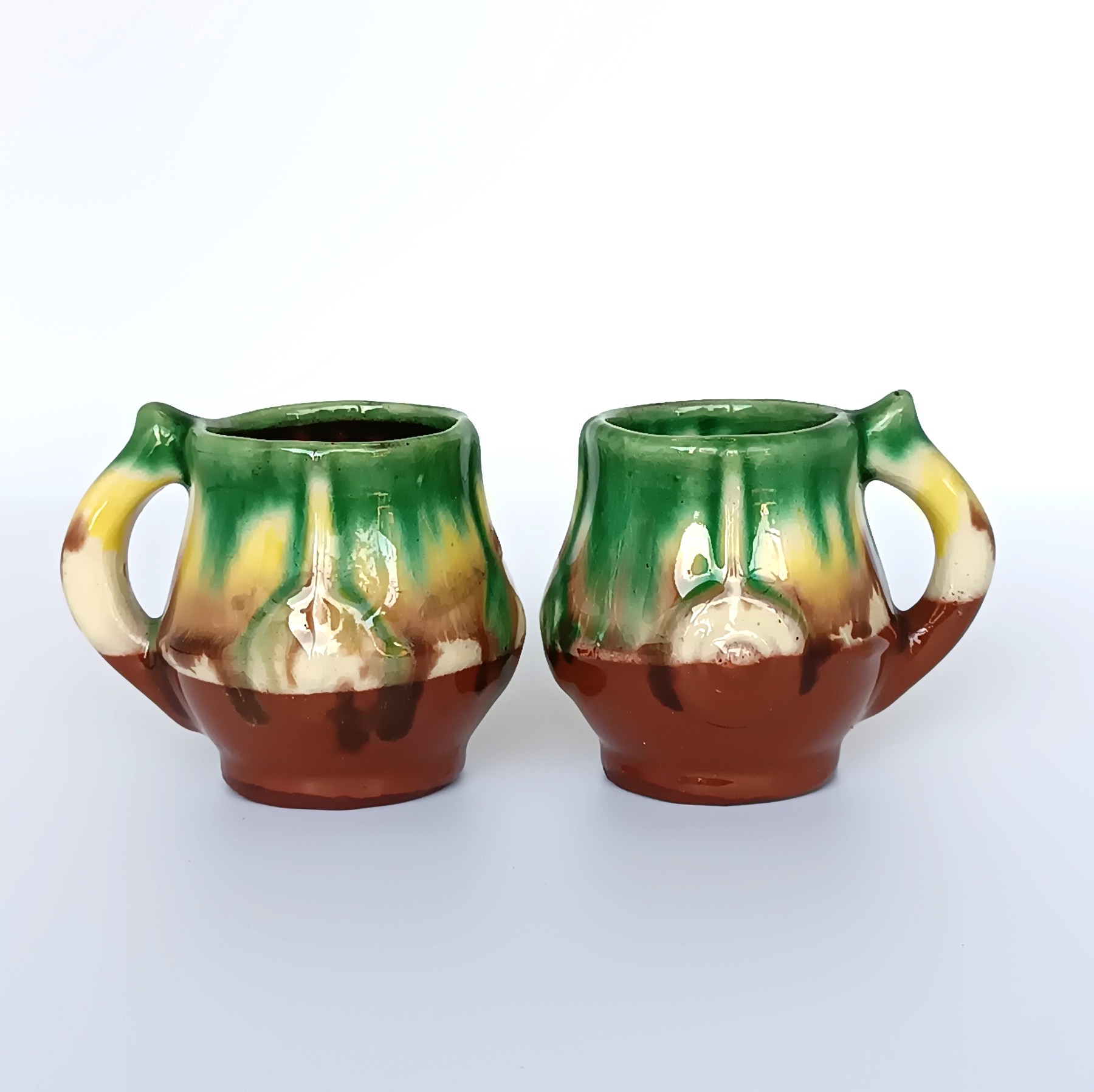 Pair of vintage Bulgarian glazed ceramic rakia cups in Troyan style with green, yellow, cream and brown decoration