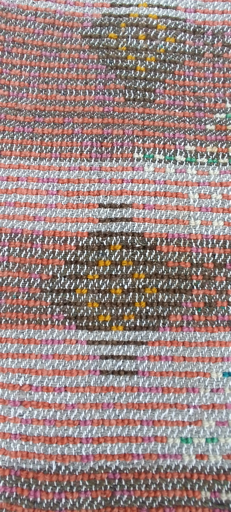 Close-up of the reverse side of a vintage Bulgarian wool kitenik showing the woven foundation, multicoloured yarns and handwoven construction