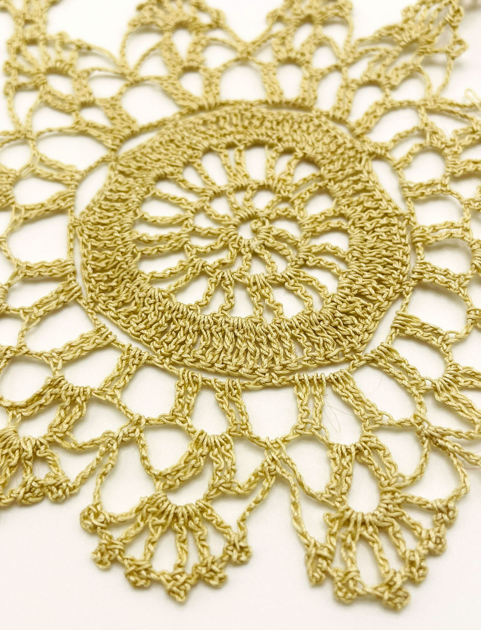 Close-up of a vintage handmade gold-tone crochet doily showing an intricate openwork rosette motif, 30 × 22 cm (11.8 × 8.7 in)