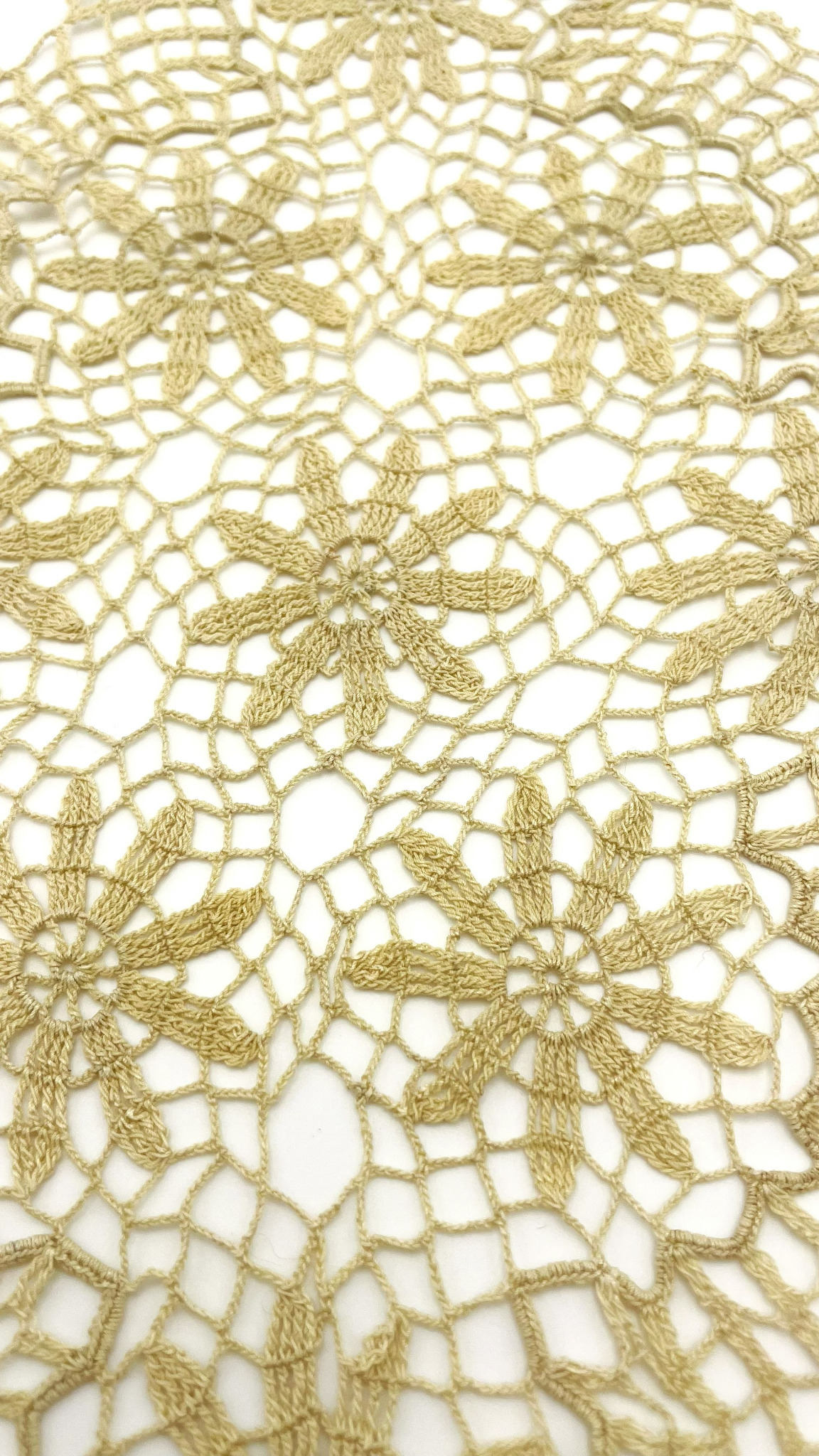 Close-up of a vintage hand-crocheted doily from the 1930s–1940s with connected floral motifs and fine openwork crochet