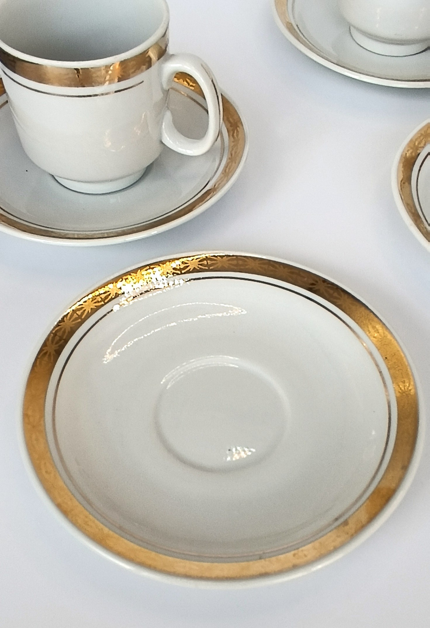 Close-up of a vintage Bulgarian Kitka porcelain saucer with broad gold-tone border and fine decorative detailing