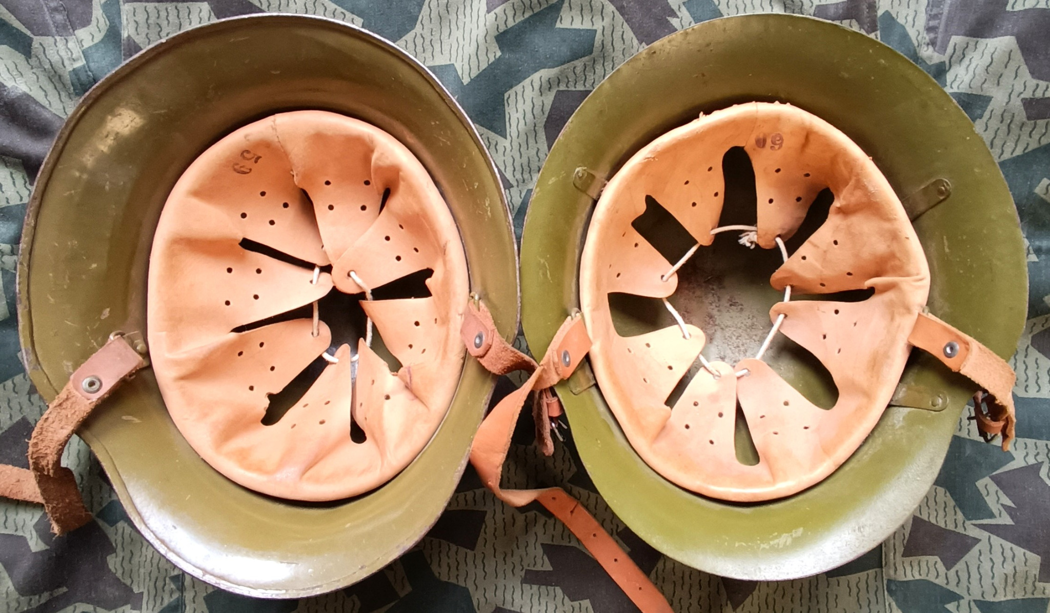 Interior comparison of Bulgarian M36A helmet on left and M36C on right with perforated leather liners, adjustment cords, rivets and chinstraps