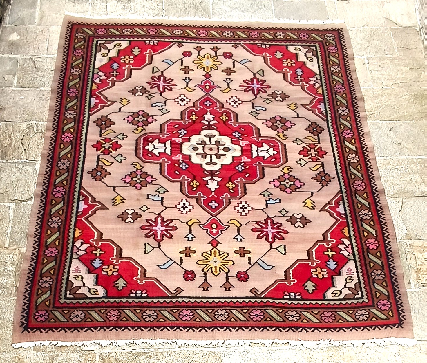 Traditional Kotel rug with cream field and red central medallion floral pattern