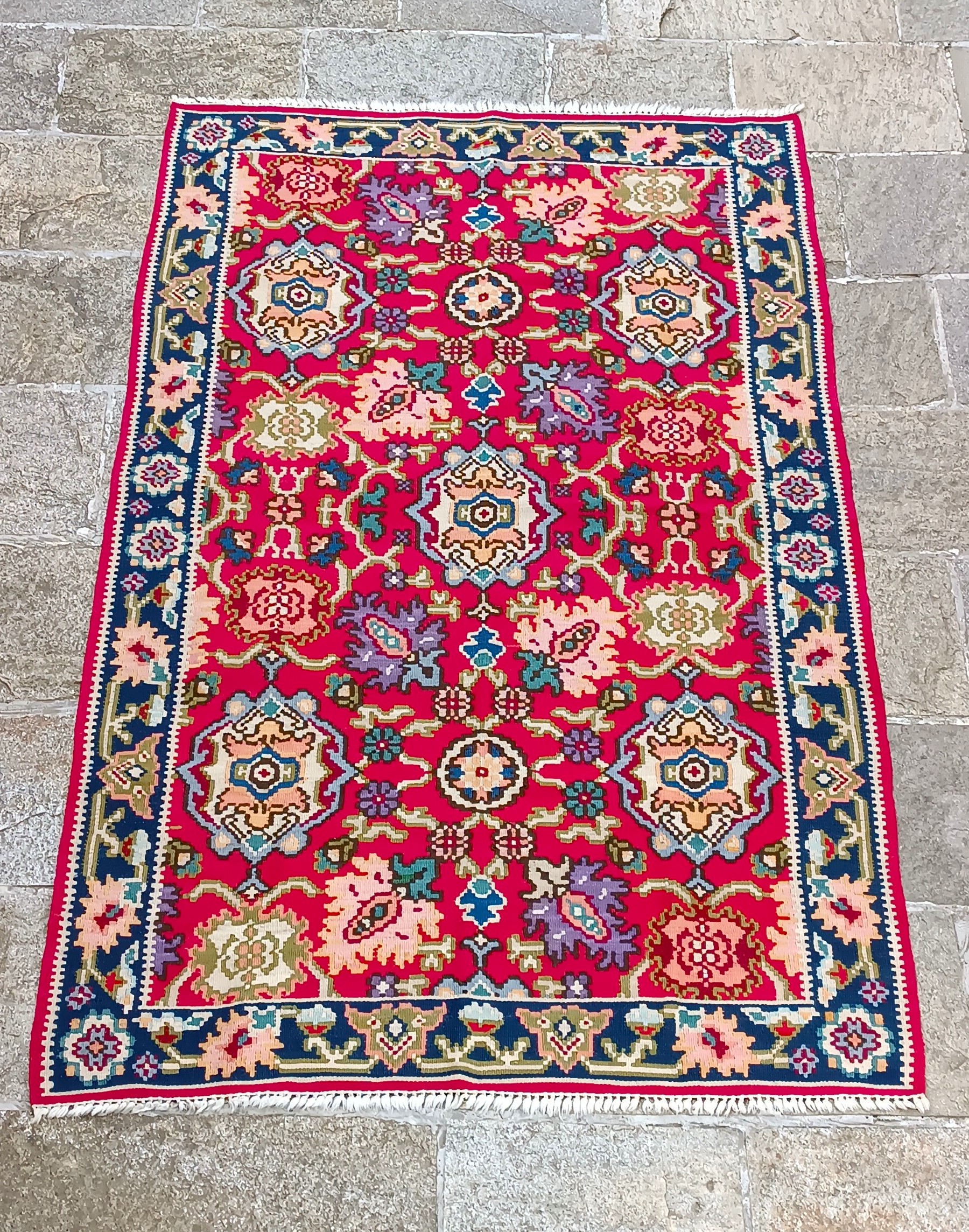 Traditional Kotel rug with red floral pattern and dark blue border