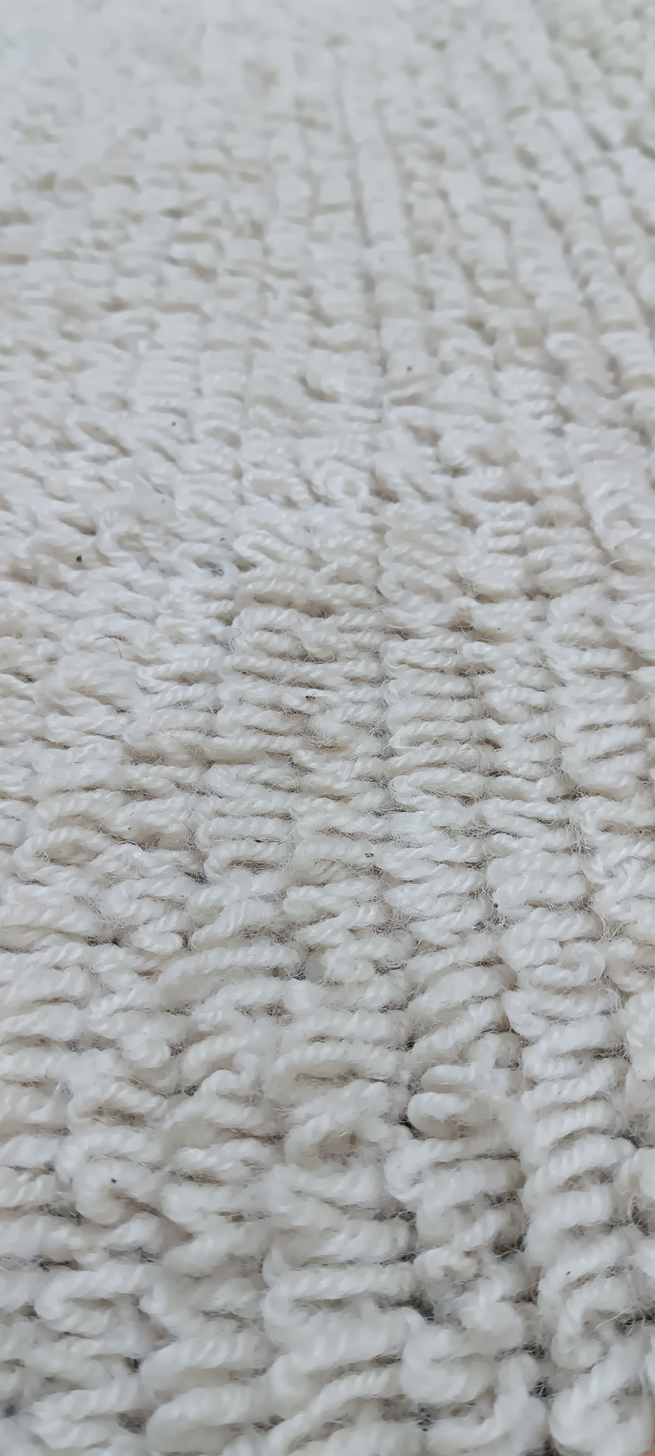 Macro detail of a vintage Balkan handwoven wool runner showing dense cream wool loops and textured pile
