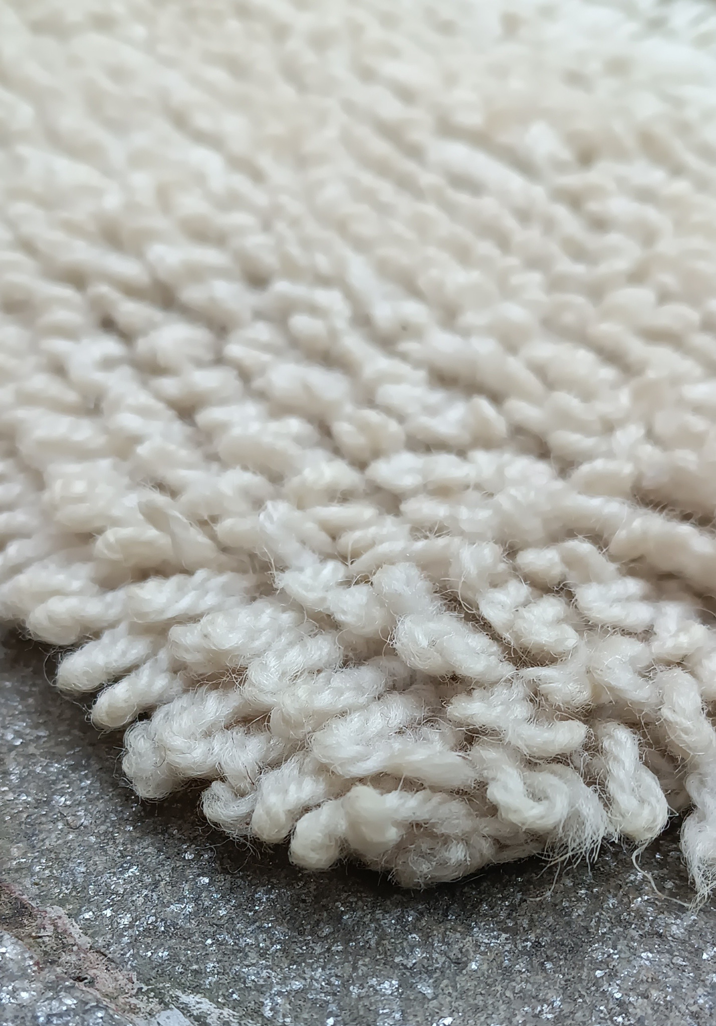 Close-up of a vintage Balkan handwoven wool runner showing dense cream long pile, twisted wool loops and soft textured surface