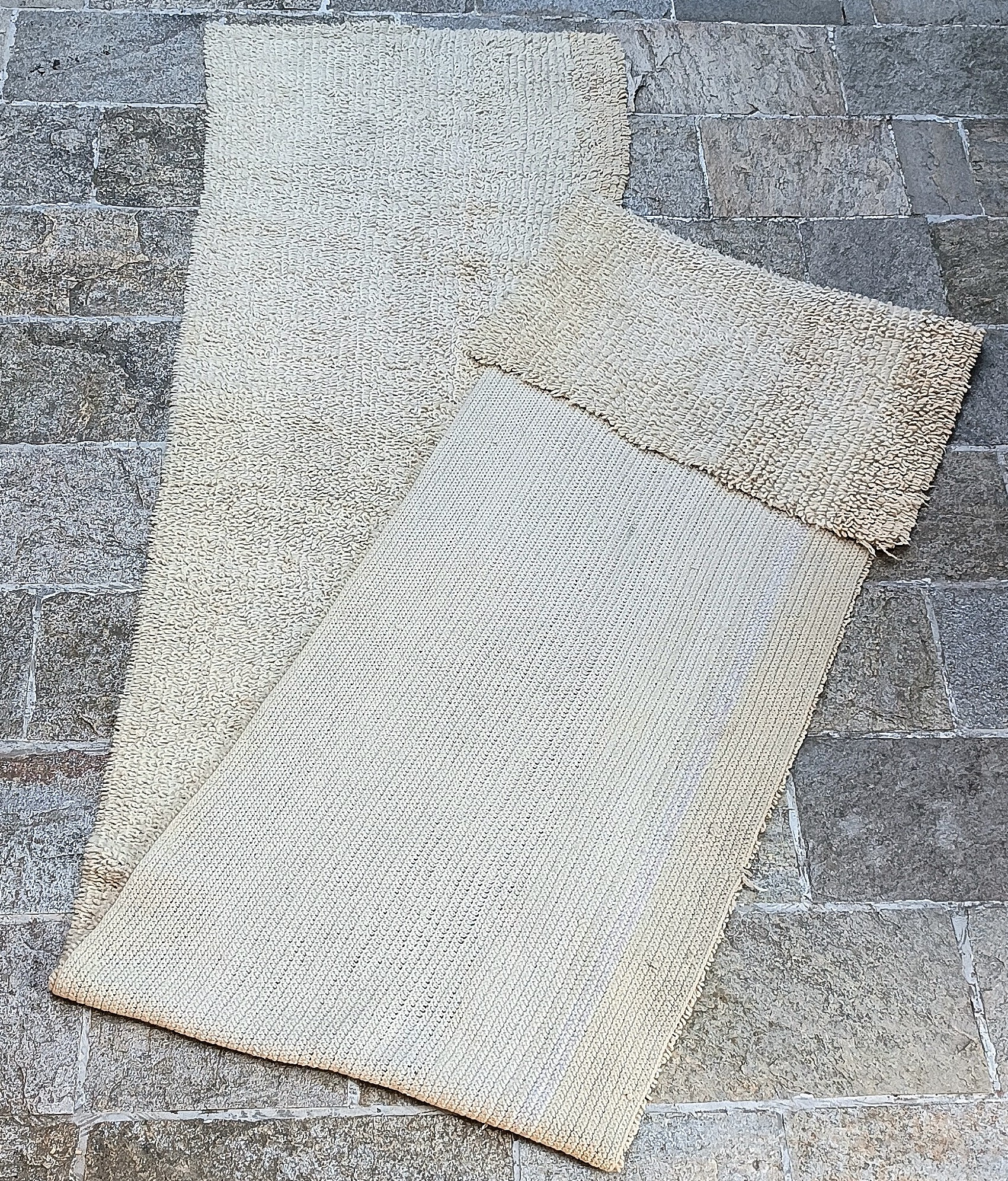 Reverse side of a vintage Balkan handwoven wool runner showing the dense woven foundation and folded cream wool pile