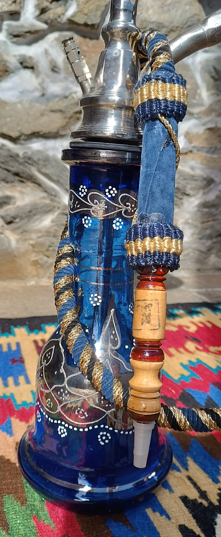 Close-up of the cobalt-blue decorated glass base of a vintage Egyptian Yehia El Khawanky hookah with white floral motifs and original braided hose