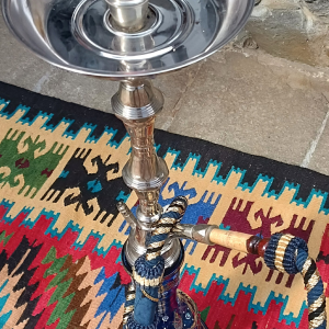 Top view of a vintage Yehia El Khawanky Egyptian hookah with polished metal charcoal tray, cobalt-blue decorated glass base and original blue-and-gold braided hose.